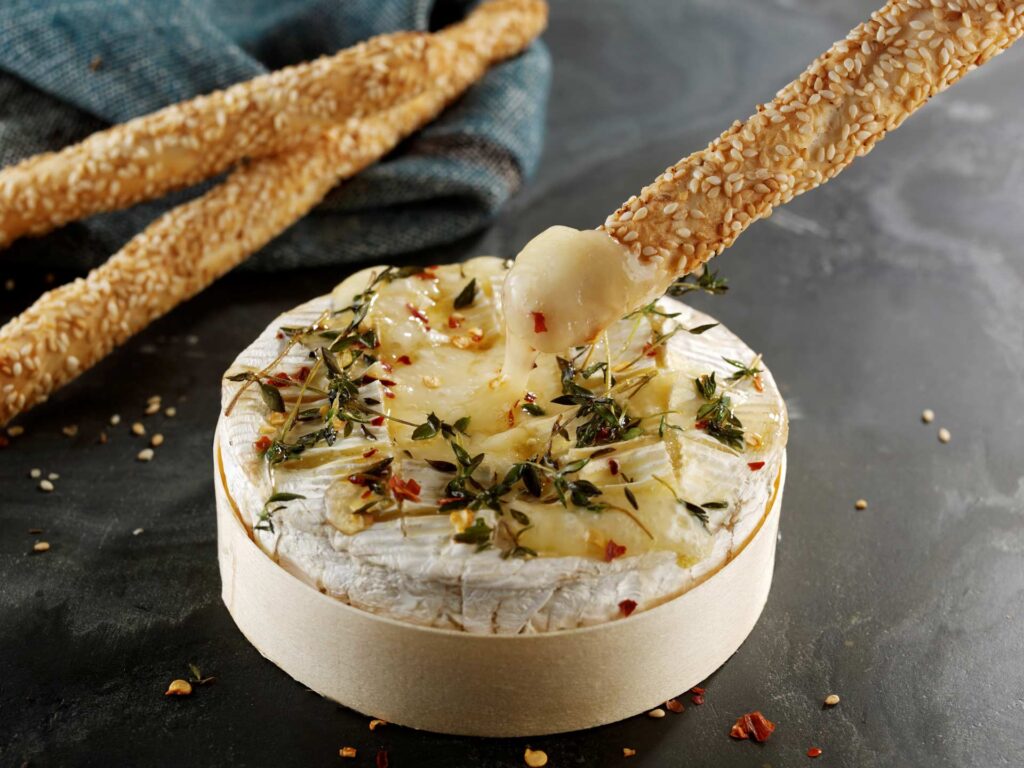 A baked camembert with honey, thyme and breadsticks